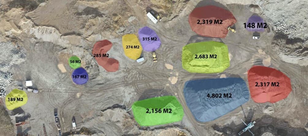 Industrial site with color-coded stockpile volume measurements from drone survey